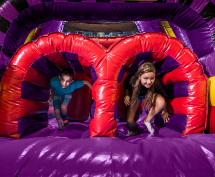 two kids running through inflatable at kids birthday party venue