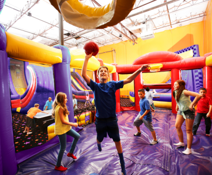 kid playing basketball on inflatable at kids birthday party venue 