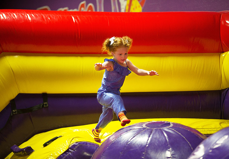 Girl jumping across giant inflatable ride.